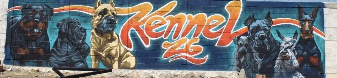 Fachada de Kennel 26: un mural con el nombre Kennel 26 en letras naranjas, rodeado de perros pintados